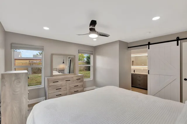 a bedroom with a bed a chandelier and a dresser
