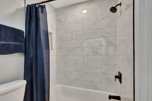 a bathroom with a shower a toilet and sink