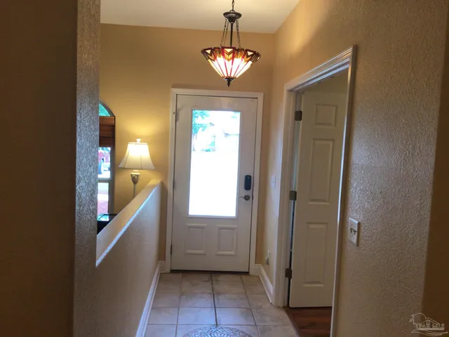 a view of a hallway with windows and chandelier