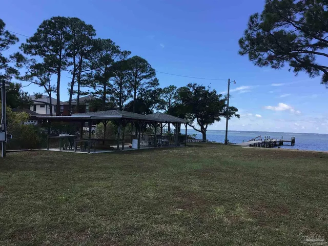 a view of a big house with a big yard and a large tree
