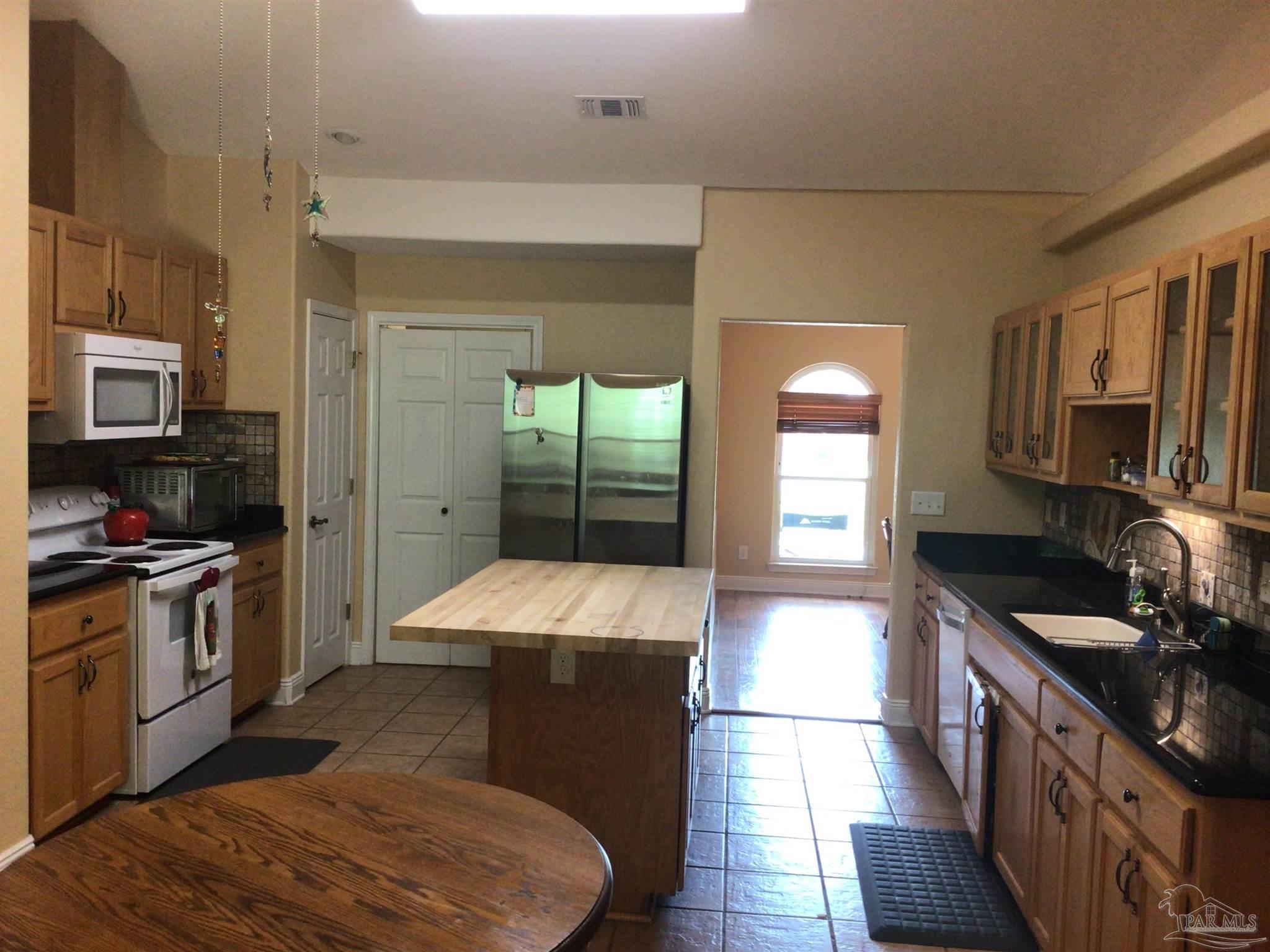 5668 Als Way Milton, FL 32583 - Photo 10 of 48 a kitchen with stainless steel appliances granite countertop a stove a sink and a refrigerator