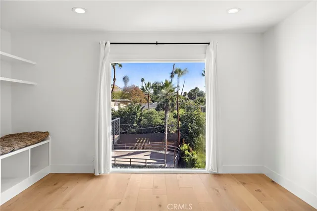 a view of a room with wooden floor and a potted plant