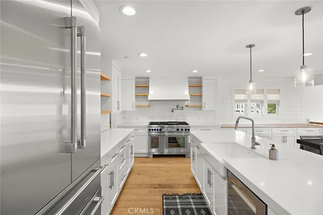 a kitchen with stainless steel appliances granite countertop a sink a stove and a refrigerator