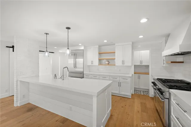 a kitchen with white cabinets and appliances