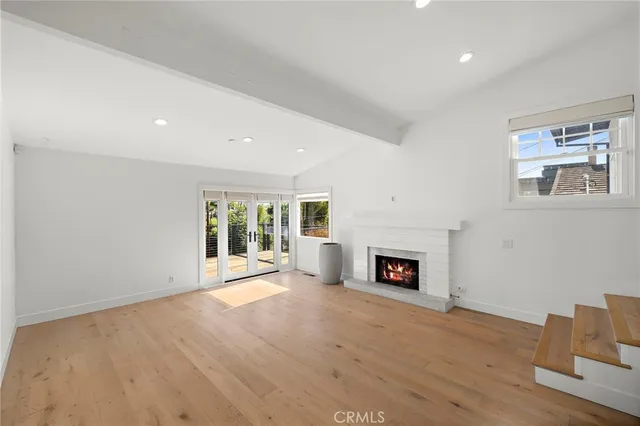 a view of a livingroom with a fireplace wooden floor and window
