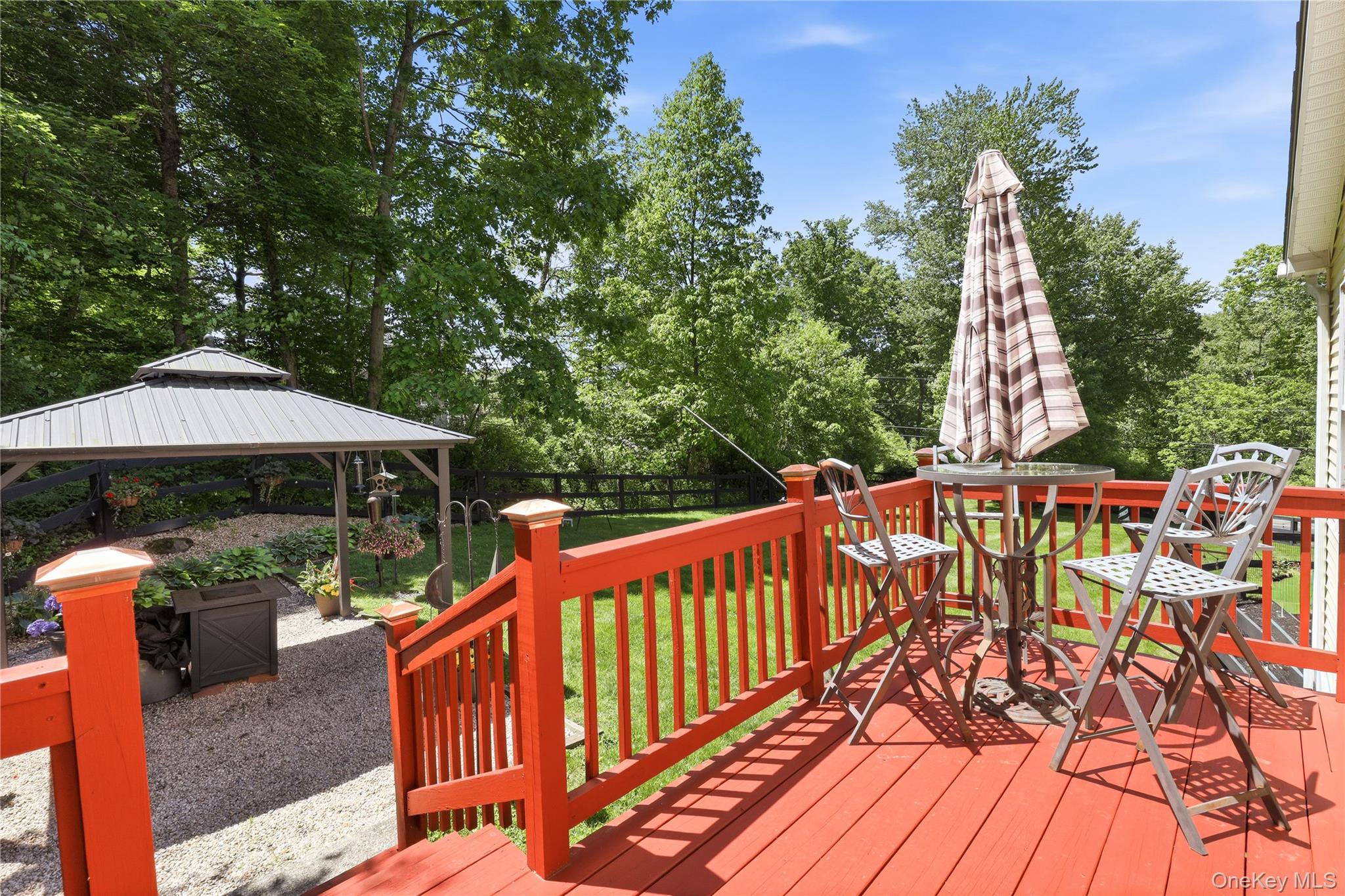 590 Farm To Market Road Brewster, NY 10509 - Photo 30 of 32 a view of a roof deck with table and chairs under an umbrella with wooden floor