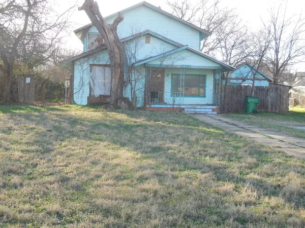 a view of a house with a yard and large tree