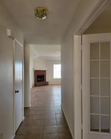 a view of a hallway with wooden floor and a bathroom