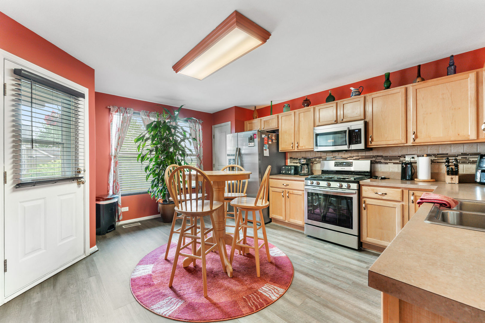 2539 Emily Lane Elgin, IL 60124 - Photo 5 of 15 a kitchen with stainless steel appliances a stove a sink a microwave a dining table and chairs
