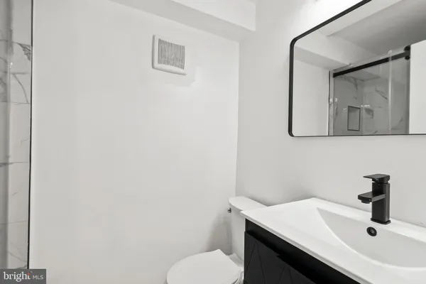 a bathroom with a sink a toilet and mirror
