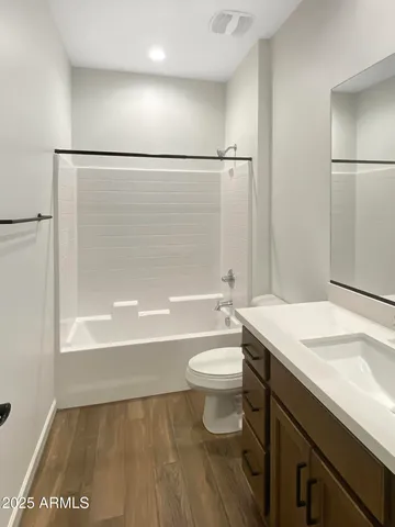 a bathroom with a sink a toilet a mirror and bathtub