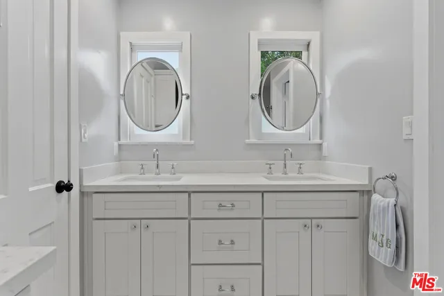 a bathroom with 2 sink and a mirror