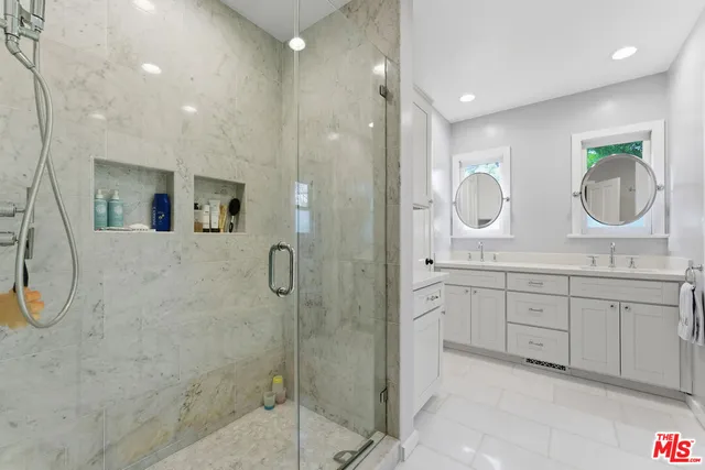 a spacious bathroom with a granite countertop sink a mirror and shower