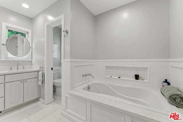 a bathroom with a tub sink and mirror