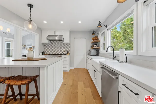 a large white kitchen with a large window