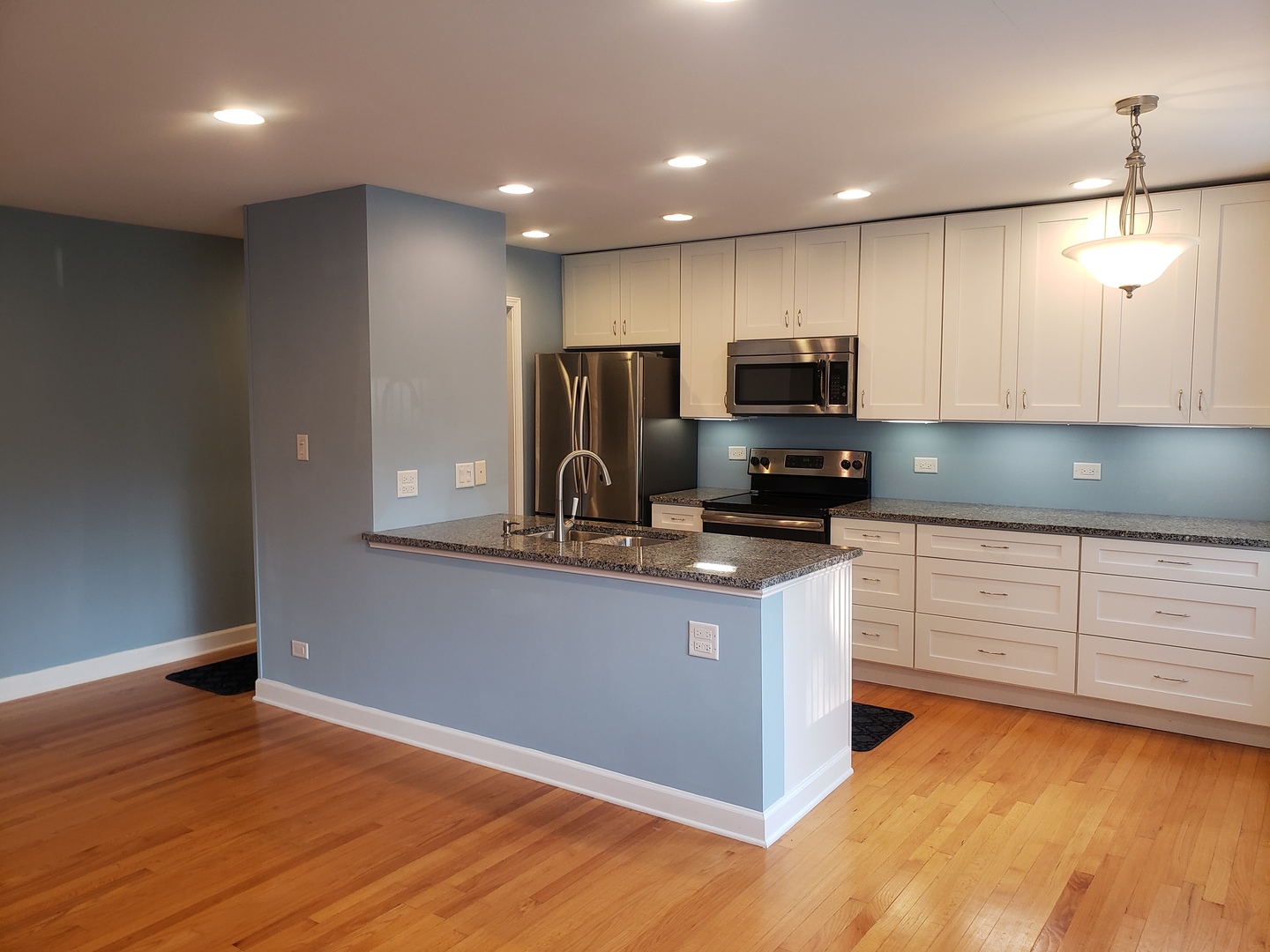 705 Strom Drive, Unit 2A West Dundee, IL 60118 - Photo 5 of 13 a kitchen with kitchen island white cabinets and black appliances