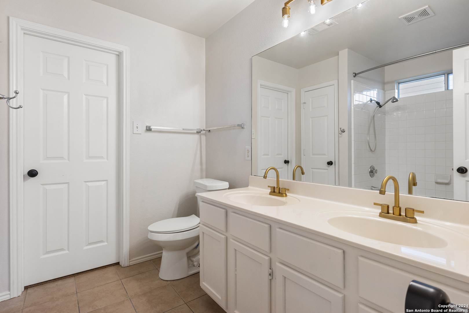 5211 Stormy Autumn San Antonio, TX 78247 - Photo 12 of 24 a bathroom with a double vanity sink toilet and a mirror