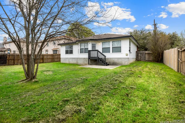 a front view of a house with yard and tree
