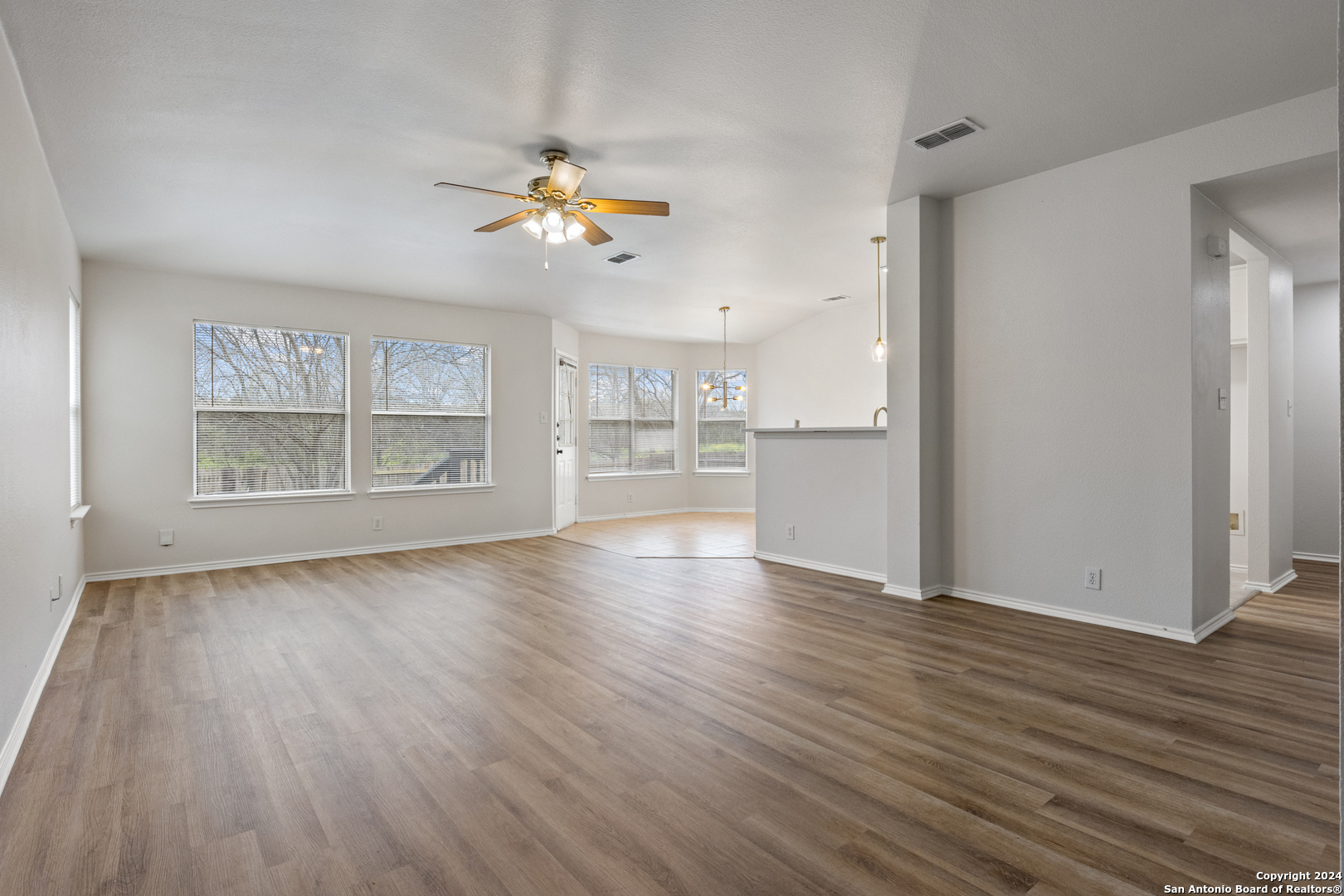 5211 Stormy Autumn San Antonio, TX 78247 - Photo 4 of 24 an empty room with wooden floor cabinet and windows