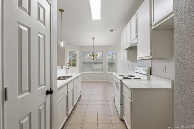 a kitchen with a sink stove and cabinets