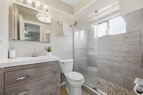 a bathroom with a sink toilet and shower
