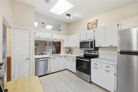 a kitchen with white cabinets and white appliances