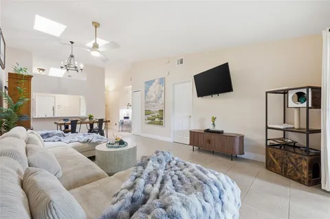 a living room with furniture a flat screen tv and kitchen view