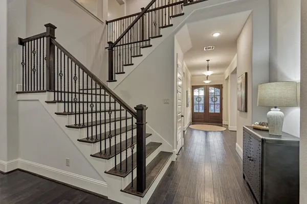 an empty room with chandelier fan and windows