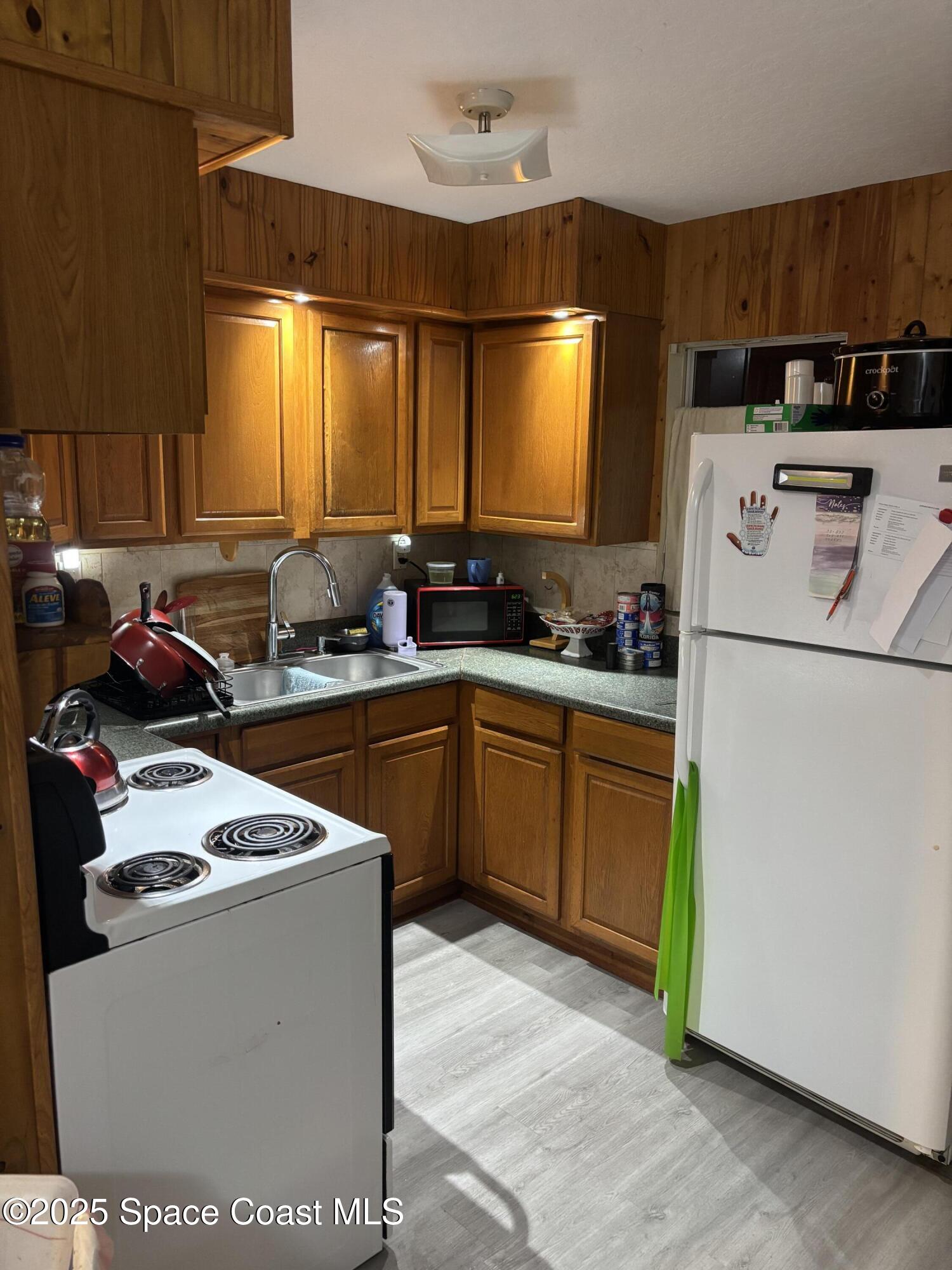 514 Donley Street Cocoa, FL 32922 - Photo 14 of 22 a kitchen with sink a refrigerator and a stove top oven