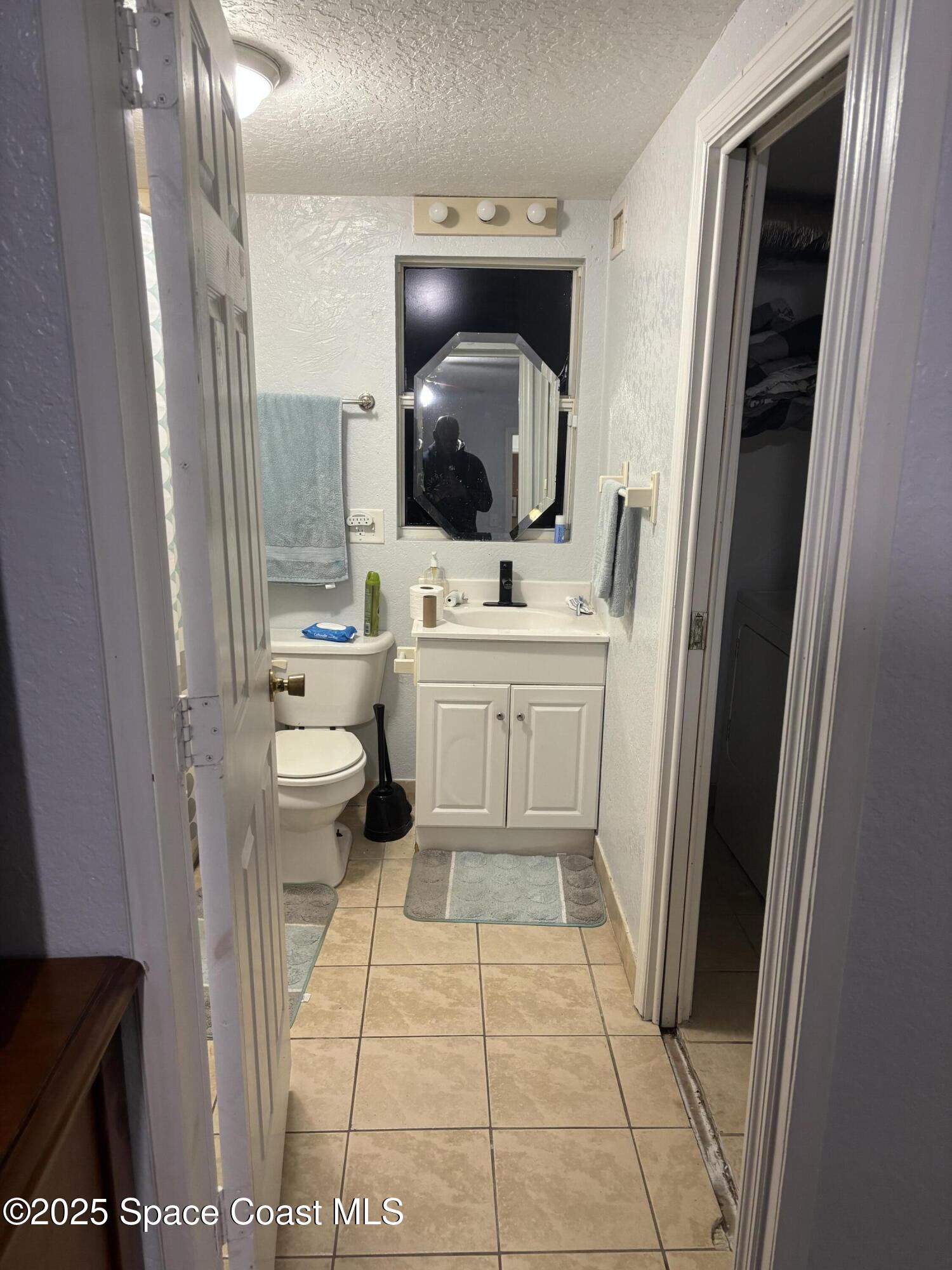 514 Donley Street Cocoa, FL 32922 - Photo 9 of 22 a bathroom with a toilet a sink and a mirror