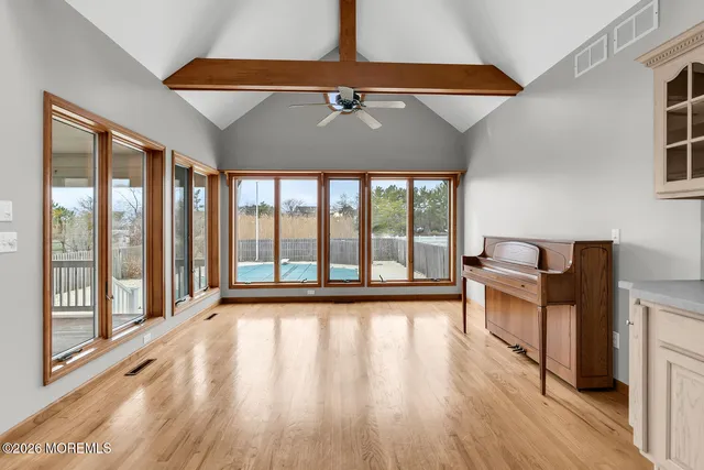 a dining room with wooden floor a chandelier a glass table and chairs