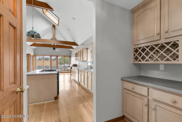 a kitchen with kitchen island granite countertop a stove top oven a refrigerator a sink and dishwasher with wooden floor