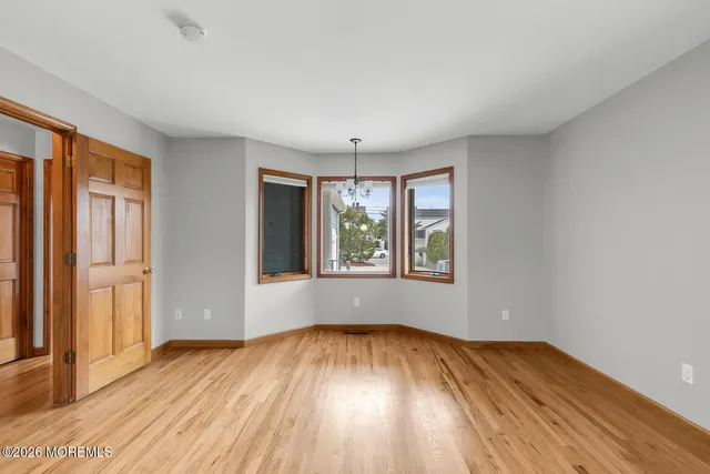 an empty room with a window and a projector screen