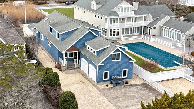 an aerial view of residential houses with outdoor space and trees