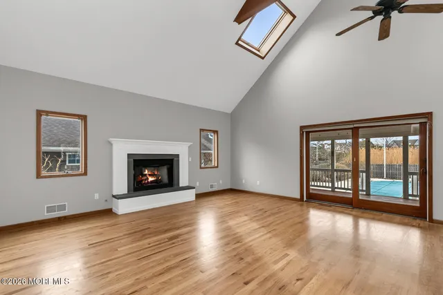 wooden floor fireplace and windows in an empty room