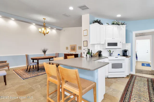 a kitchen with stainless steel appliances kitchen island granite countertop a stove and white cabinets
