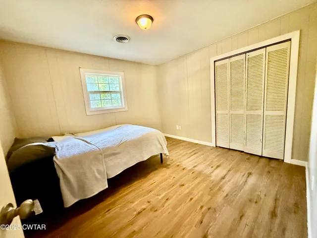a bedroom with a bed and wooden floor
