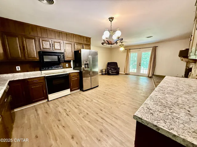 a large kitchen with stainless steel appliances granite countertop a stove and refrigerator
