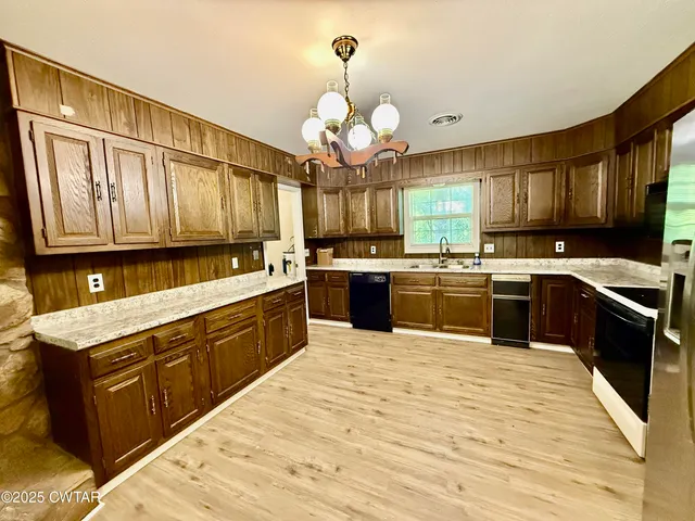a kitchen with a stove sink cabinets and window