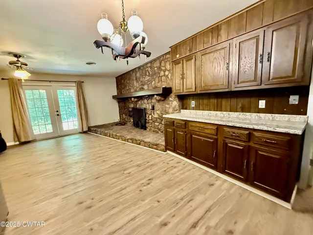 a open kitchen with stainless steel appliances granite countertop a sink dishwasher stove and refrigerator with wooden floor