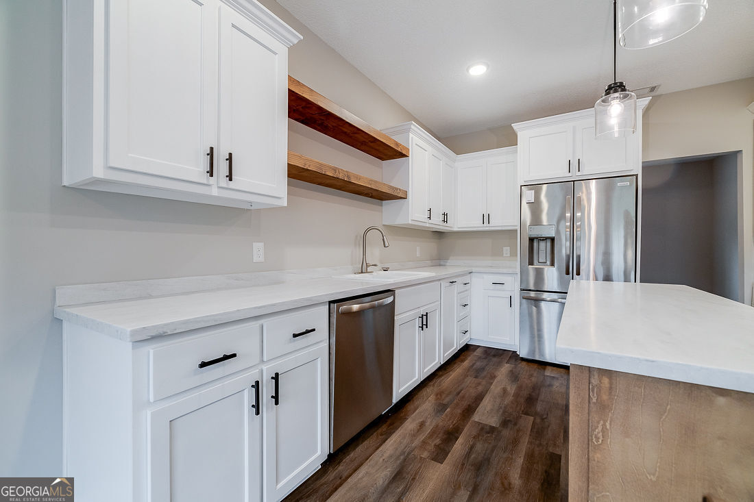127 Winding Way Road Pembroke, GA 31321 - Photo 12 of 38 a kitchen with white cabinets and stainless steel appliances