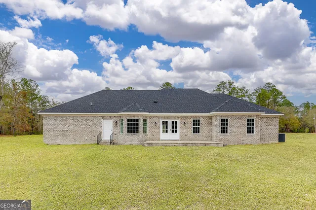 a view of a large pool with a lawn chairs and a yard