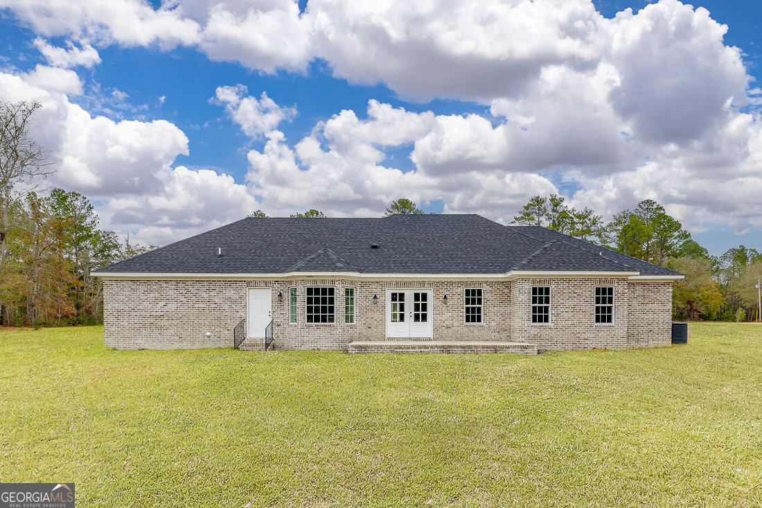 127 Winding Way Road Pembroke, GA 31321 - Photo 31 of 38 a view of a large pool with a lawn chairs and a yard
