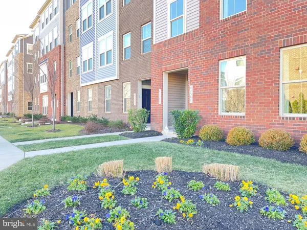 a front view of a house with a big yard and potted plants