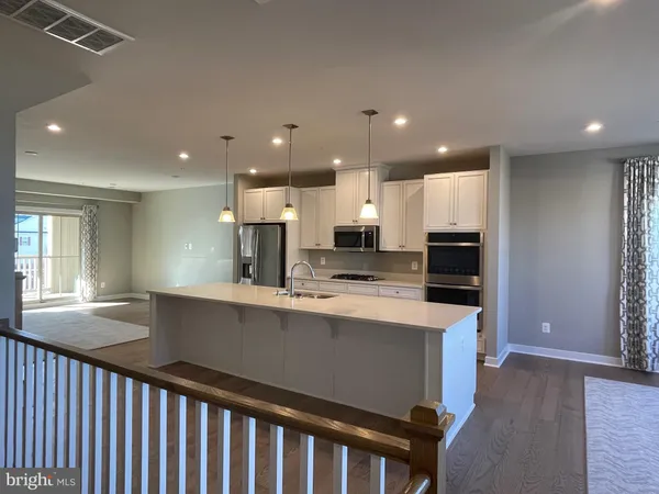 a kitchen with kitchen island a sink appliances and a counter top space