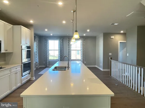 a kitchen with stainless steel appliances a dining table chairs refrigerator and stove