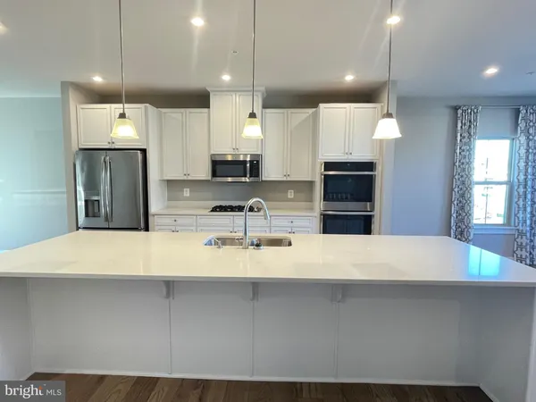 a large kitchen with a large refrigerator a sink and a stove
