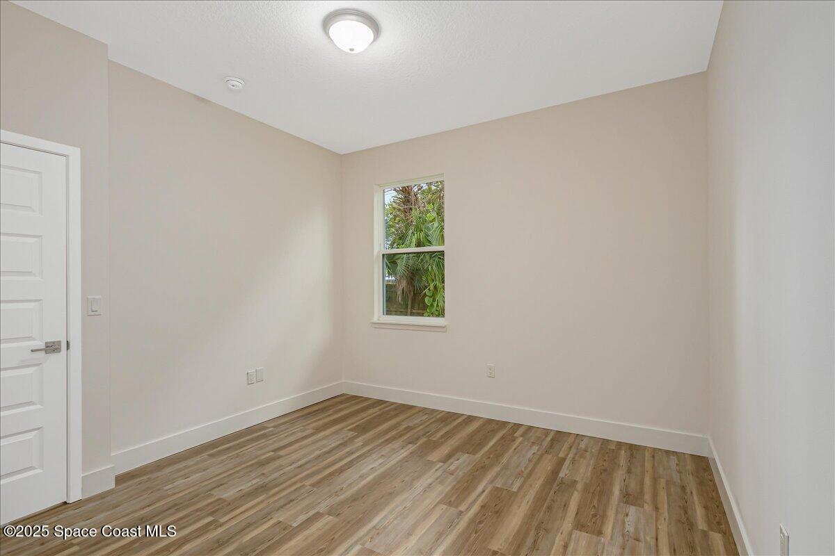 958 Chace Lane Northeast Palm Bay, FL 32905 - Photo 13 of 27 an empty room with wooden floor and windows