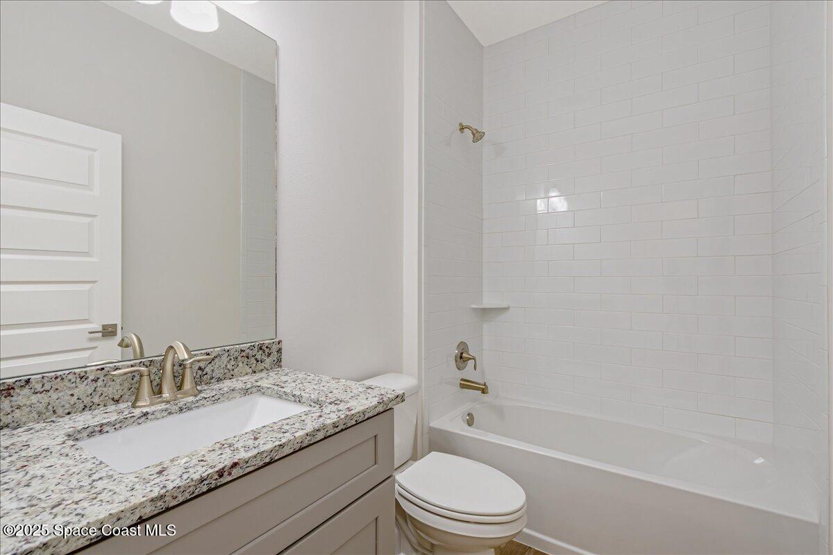 958 Chace Lane Northeast Palm Bay, FL 32905 - Photo 15 of 27 a bathroom with a granite countertop sink a toilet and bathtub