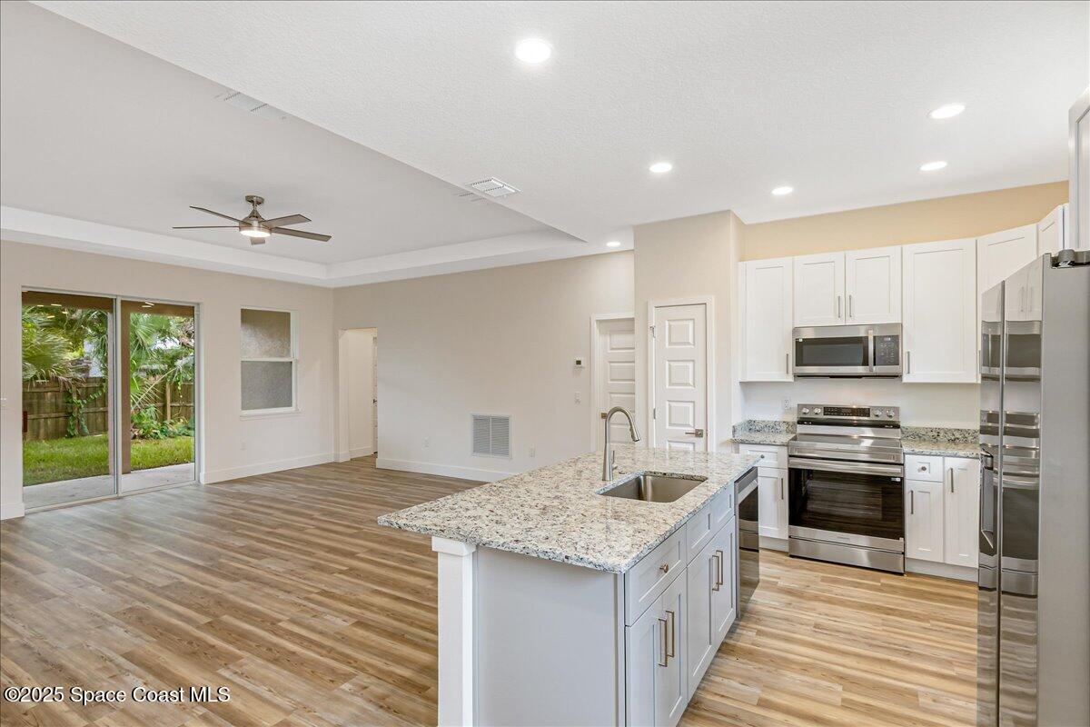 a kitchen with stainless steel appliances granite countertop a sink stove and refrigerator